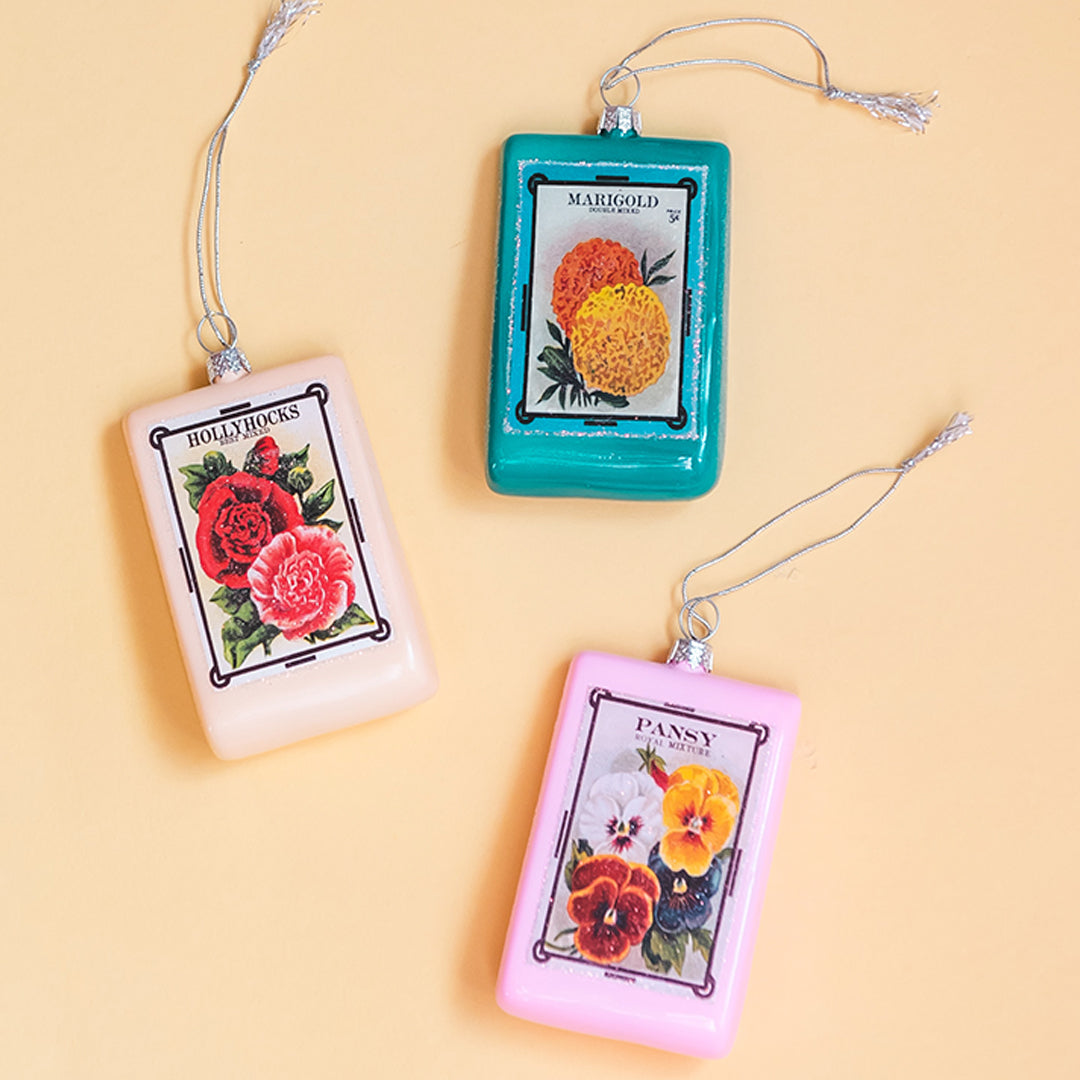 Flower seed packet ornaments. There are Marigold, Hollyhocks and Pansy seeds.