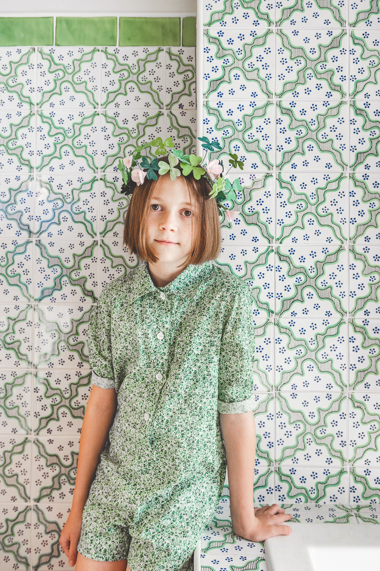 Paper shamrocks and paper flower templates to make a shamrock wreath crown. Green floral outfit with a geometric tile backdrop